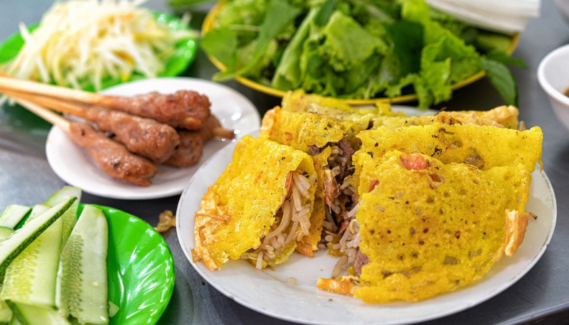 Đĩa bánh xèo giòn tan và nem lụi nướng thơm lừng, ăn kèm rau sống và nước chấm đặc biệt của Đà Nẵng.